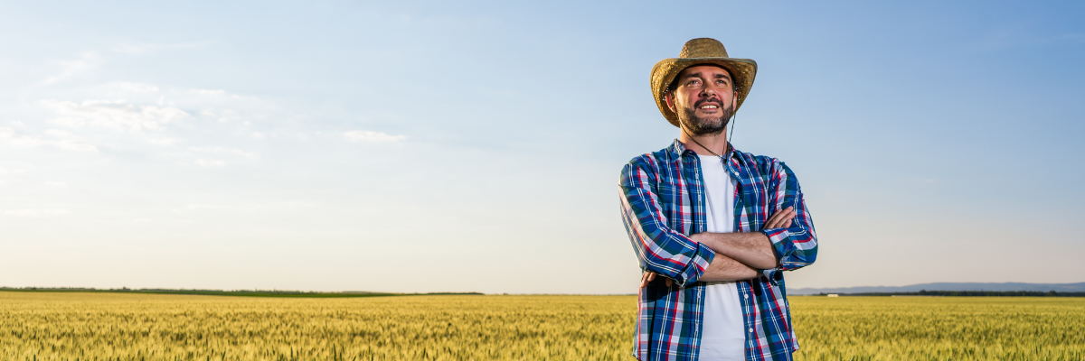 mężczyzna w kapeluszu stojący na polu
