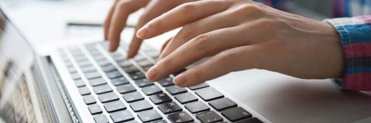 ręce piszące na klawiaturze komputera