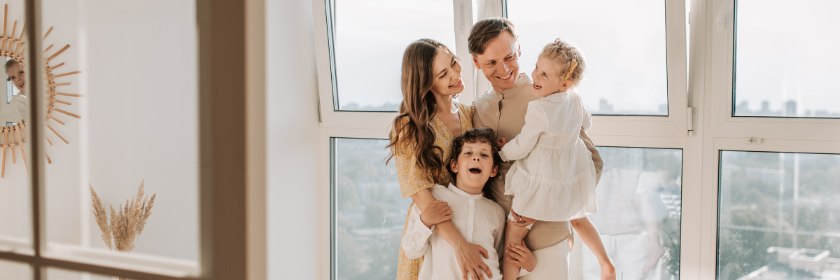 czteroosobowa rodzina przed oknem