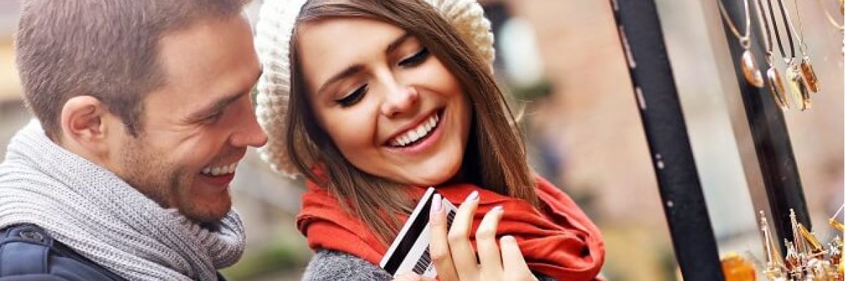uśmiechnięta para trzymająca kartę płatniczą
