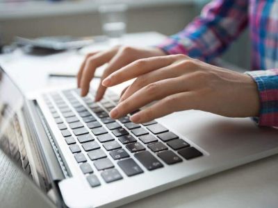 ręce piszące na klawiaturze komputera