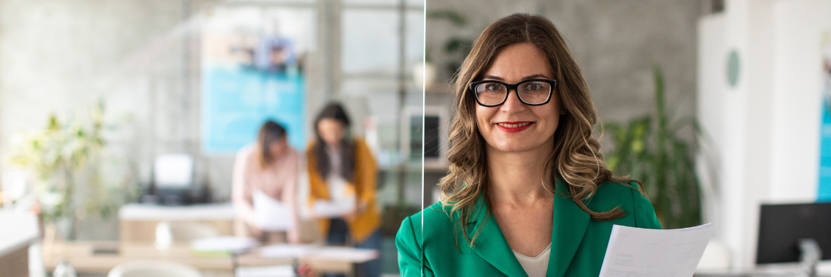 uśmiechnięta kobieta z dokumentami w przestrzeni biurowej