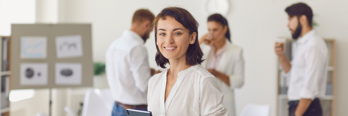 uśmiechnięta kobieta w białej koszuli w miejscu pracy